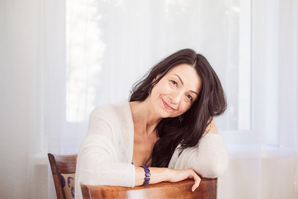 Woman resting her head on her hand at a table