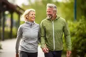 Older couple walking together outdoors in athletic wear