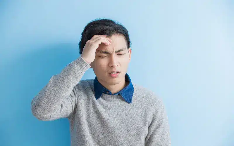 Man holding his forehead showing signs of a headache
