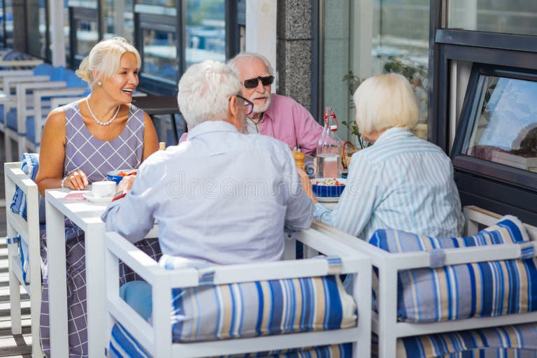 Group of older adults sitting together outdoors smiling