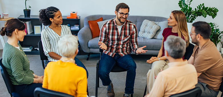 photo of a group of people sitting in a circle talking