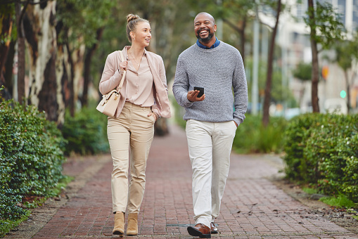 Man and woman walking together outdoors surrounded by trees