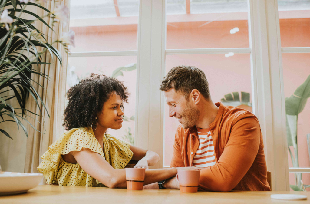 phot of a man and woman sitting at a counter at a cafe having coffee