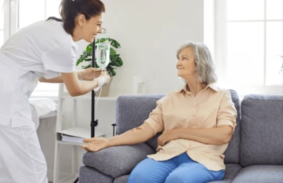 Healthcare provider checking an older patient seated on a couch