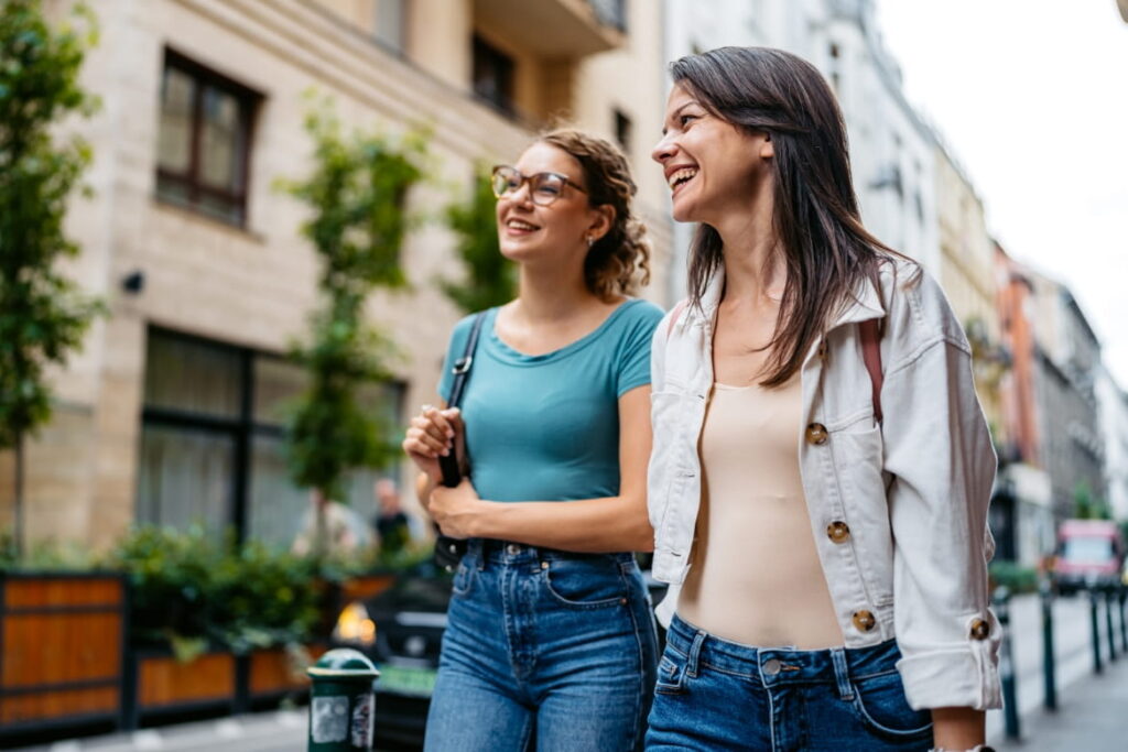 Two women smiling while walking together outdoors