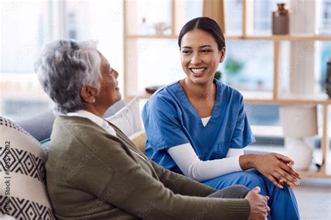 Smiling healthcare provider talking with an older patient at home