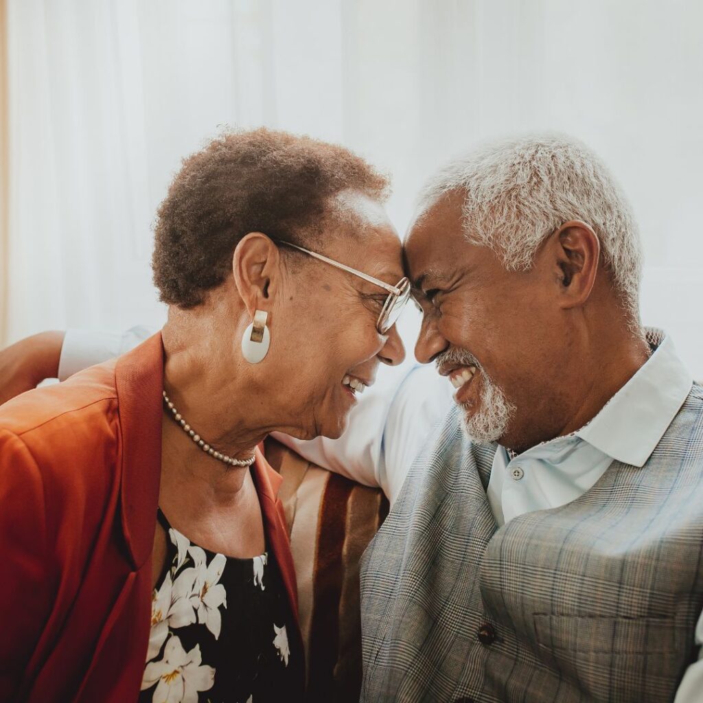 Older couple embracing and smiling with foreheads touching