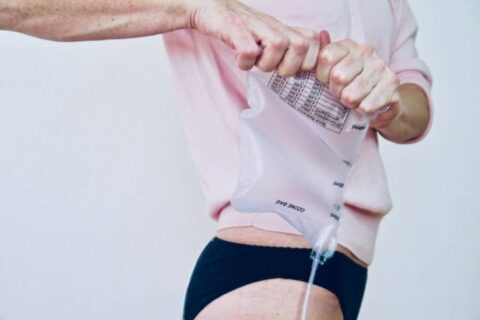 Close-up of a person adjusting the waistband of light clothing