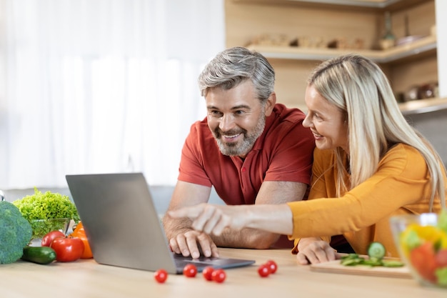 Man and woman looking at a laptop together at a table
