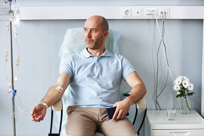 Man sitting in a treatment chair receiving IV therapy