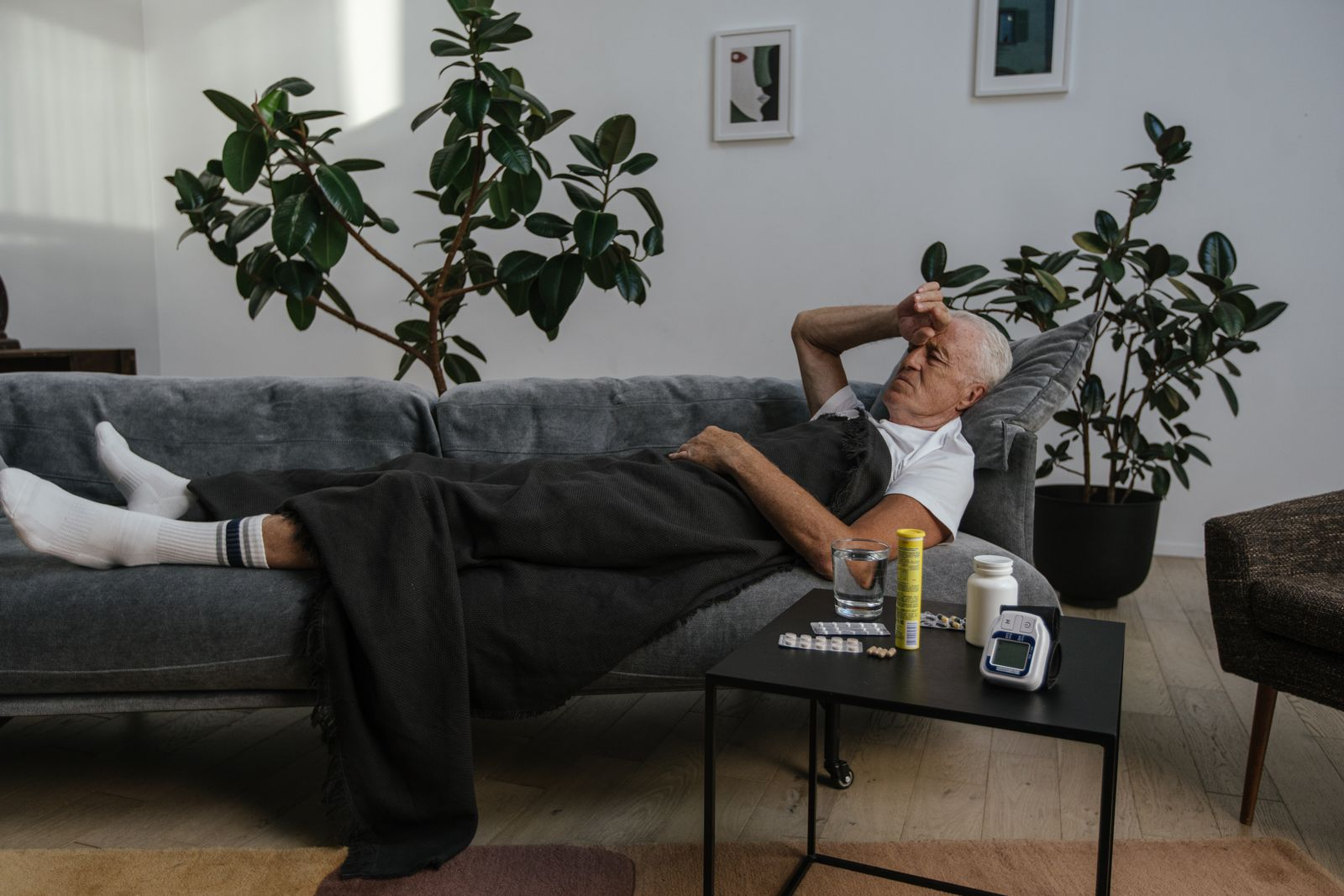 Well-dressed man resting on a sofa fatigued from chronic illness that is not visible from the outside