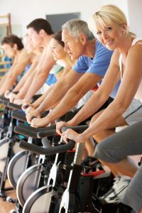 Group of people using stationary bikes together in a spin class